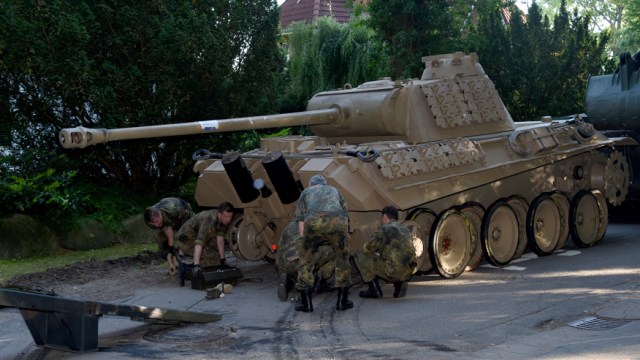 In this July 2, 2015 picture a  World War II -era Panther  tank  is prepared  for transportation from a residential property in Heikendorf,  northern Germany.  Authorities have seized a 45-ton Panther tank, a flak canon and multiple other World War II-era military weapons in a raid on a 78-year-old collector's storage facility in northern Germany. Kiel prosecutor Birgit Hess said the collector is being investigated for possibly violating German weapons laws but his attorney Peter Gramsch told the dpa news agency all the items were properly demilitarized and registered.  (Carsten Rehder/dpa via AP)